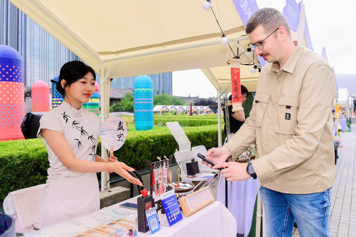 An international visitor paying with Alipay at a souvenir store in China.